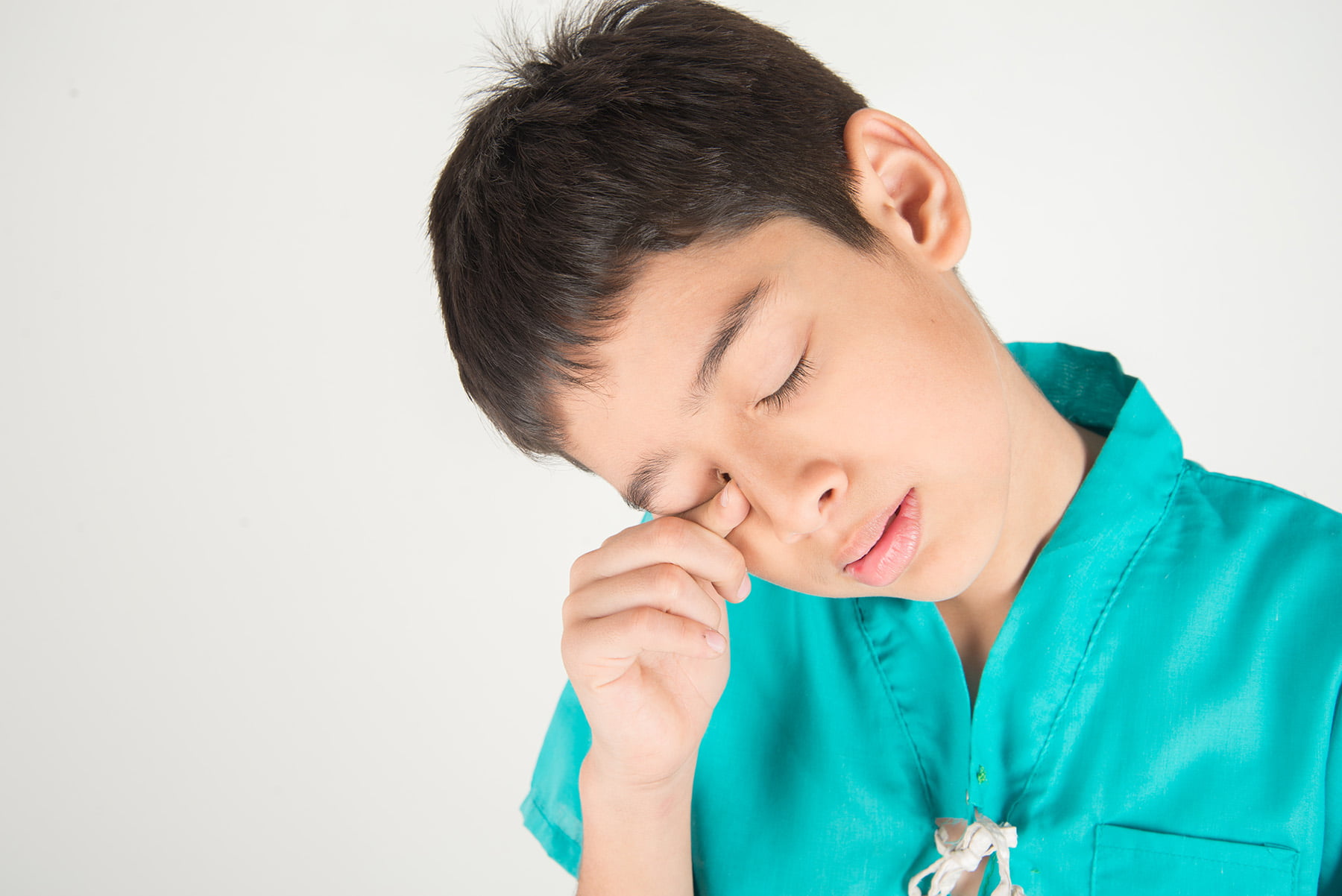 Male child wiping his lower eyelid with finger